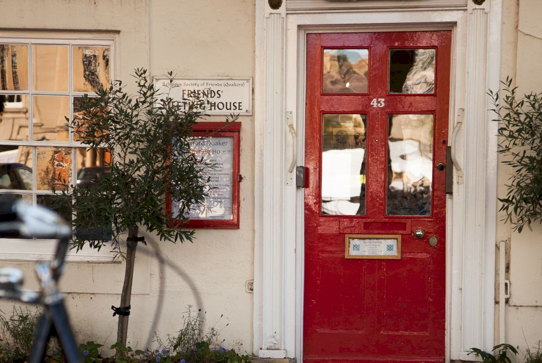 A red door with a number 43 next to a sign that reads